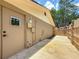 Side view of the tan, block constructed garage with an outdoor shower and gate at 1025 Reading Rd, Lutz, FL 33558
