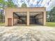 Exterior of a two-car garage with opened doors showing metal beams and an upper storage area at 1025 Reading Rd, Lutz, FL 33558