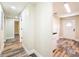 Hallway with wood-look floors leading to a white door and other rooms at 1025 Reading Rd, Lutz, FL 33558