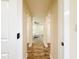Hallway with wood-look floors leading to a bedroom with neutral carpet at 1025 Reading Rd, Lutz, FL 33558