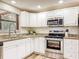 Updated kitchen with white cabinets, granite countertops, subway tile backsplash, and stainless steel appliances at 1025 Reading Rd, Lutz, FL 33558
