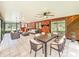 Expansive living room features lots of natural light, wood paneled walls, access to outdoor areas, and dining table at 1025 Reading Rd, Lutz, FL 33558