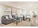 Cozy living room featuring a comfortable sofa, stylish chairs, natural light, and a seamless transition to the hallway at 1025 Reading Rd, Lutz, FL 33558