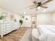 Cozy bedroom featuring wood floors, a white dresser, decorative mirrors, and a doorway view into the bathroom at 1025 Reading Rd, Lutz, FL 33558