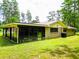 Cozy home featuring a charming screened patio and expansive lush green backyard for outdoor enjoyment at 1025 Reading Rd, Lutz, FL 33558