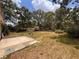 Spacious backyard features lush greenery, a stone patio, and a wooden fence, creating a private outdoor oasis at 11394 Collingswood St, Spring Hill, FL 34608