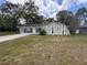 Charming one-story home with green exterior, complemented by a spacious front yard and mature trees at 11394 Collingswood St, Spring Hill, FL 34608