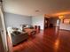 Open-concept living room featuring hardwood floors, comfortable sofas, and seamless flow to the kitchen at 11394 Collingswood St, Spring Hill, FL 34608