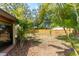 View of the backyard with a fire pit, a wood fence, tropical trees and bushes at 11988 117Th St, Seminole, FL 33778