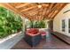 Side angle view of the covered deck with exposed rafters, wood flooring and comfortable wicker seating at 11988 117Th St, Seminole, FL 33778