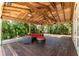 Wide angle view of deck, wood flooring, exposed rafters, comfortable seating, and lush landscaping at 11988 117Th St, Seminole, FL 33778