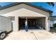 A Personal is standing in the doorway to the spacious two-car garage with ample room for storage and projects at 11988 117Th St, Seminole, FL 33778
