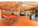 View of the inside of the spacious pool house with bamboo walls, pool table and arcade games at 11988 117Th St, Seminole, FL 33778