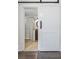 Bathroom view through the barn door with a glass shower and wood vanity at 1203 E New Orleans Ave, Tampa, FL 33603