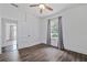 Bedroom with a ceiling fan, hardwood floors, and a window with gray curtains at 1203 E New Orleans Ave, Tampa, FL 33603