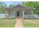 Charming bungalow showcasing a covered porch, brick walkway, and well-maintained lawn at 1203 E New Orleans Ave, Tampa, FL 33603