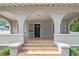 Arched covered porch with decorative columns and tile steps leading to the front door at 1203 E New Orleans Ave, Tampa, FL 33603