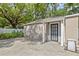 Rear view of a detached garage featuring an exterior door and concrete pad at 1203 E New Orleans Ave, Tampa, FL 33603