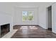 Bright living room featuring a fireplace, hardwood floors, and a large window at 1203 E New Orleans Ave, Tampa, FL 33603