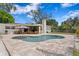 Backyard with a pool, stone pavers, a covered patio, and outdoor seating, perfect for relaxation at 125 Live Oak Ln, Largo, FL 33770