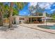 Backyard with gravel, patio, outdoor kitchen, and in-ground pool at 125 Live Oak Ln, Largo, FL 33770