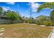 Spacious backyard featuring a lush lawn, mature trees, and a privacy fence at 125 Live Oak Ln, Largo, FL 33770