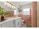 Pink and white bathroom with modern vanity and lighting at 125 Live Oak Ln, Largo, FL 33770