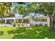 Inviting single-story home with well-kept lawn and lush landscaping at 125 Live Oak Ln, Largo, FL 33770