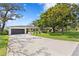Well-maintained single-story home with a spacious driveway and mature trees at 125 Live Oak Ln, Largo, FL 33770