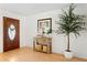 Welcoming foyer with hardwood floors, stylish console table, and an elegant decorative tree at 125 Live Oak Ln, Largo, FL 33770