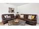 Comfortable living room with leather sofas, wood floors, and a pass-through window to the kitchen at 125 Live Oak Ln, Largo, FL 33770