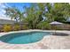 Landscaped pool area with stone pavers and a refreshing pool with an umbrella for shade at 125 Live Oak Ln, Largo, FL 33770