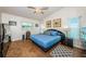 Serene main bedroom with a blue color scheme, stylish furnishings, wood-look flooring, and ample natural light at 12873 Cumberland Dr, Largo, FL 33773