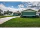 Exterior view of home featuring green siding, a well-kept lawn, and a long driveway at 12873 Cumberland Dr, Largo, FL 33773