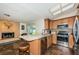 Modern kitchen with stainless steel appliances, mosaic backsplash, breakfast bar, and adjacent living space with a cozy fireplace at 12873 Cumberland Dr, Largo, FL 33773
