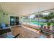 Relaxing screened patio featuring brick flooring and comfortable seating overlooking the sparkling pool at 12873 Cumberland Dr, Largo, FL 33773