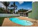Backyard features a kidney-shaped pool, lush landscaping, and a covered patio for relaxing at 12873 Cumberland Dr, Largo, FL 33773