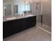 A modern bathroom includes a glass shower, dual sink vanity with granite countertops, and a large mirror at 13111 Pepper Stem St, Spring Hill, FL 34609