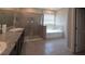 A bathroom showcases a soaking tub, walk-in glass shower, double sinks, and dark cabinetry, providing a spa-like experience at 13111 Pepper Stem St, Spring Hill, FL 34609