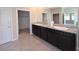 A bathroom features double sinks, granite countertops, dark cabinetry, and a walk-in closet at 13111 Pepper Stem St, Spring Hill, FL 34609