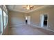 A spacious bedroom boasts a tray ceiling, ceiling fan, and a view of an open doorway to another room at 13111 Pepper Stem St, Spring Hill, FL 34609