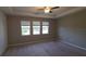 A bedroom with three large windows features a tray ceiling, ceiling fan, and neutral-toned walls creating a serene and relaxing atmosphere at 13111 Pepper Stem St, Spring Hill, FL 34609