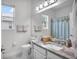 Well-lit bathroom featuring a granite countertop, modern fixtures, and a window for natural light at 13336 Graham Yarden Dr, Riverview, FL 33579
