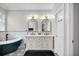 Beautiful primary bathroom featuring double sinks, decorative mirrors, and a modern soaking tub at 13336 Graham Yarden Dr, Riverview, FL 33579
