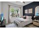 Comfortable bedroom with dark accent wall, large window, and stylish decor at 13336 Graham Yarden Dr, Riverview, FL 33579