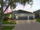 Charming home featuring a spacious three-car garage, lush landscaping, and a well-manicured lawn at 13336 Graham Yarden Dr, Riverview, FL 33579