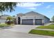 Single-story home with a three-car garage and a spacious driveway at 13336 Graham Yarden Dr, Riverview, FL 33579