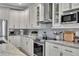 Beautiful kitchen featuring white cabinets, stainless steel appliances, and granite countertops at 13336 Graham Yarden Dr, Riverview, FL 33579