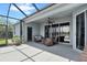 Screened-in patio with cozy seating, ceiling fan, and outdoor lighting for relaxing evenings at 13336 Graham Yarden Dr, Riverview, FL 33579