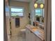 Bathroom with granite counters, white cabinets, and a window at 14530 Apache Ave, Largo, FL 33774